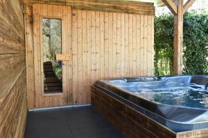 a jacuzzi tub in a wooden house at Farmhouse, Jacuzzi, Sauna, BBQ grill & Garden, Sleeps 24 in Kockengen