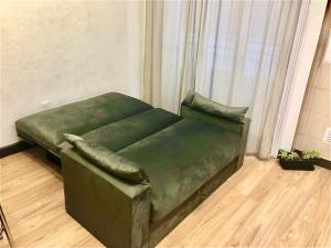 a green couch in a room with a window at Alquiler por dia "Como en Casa" Caseros, cerca de Palomar y Hurlingham in Caseros