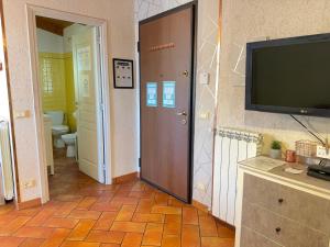 un couloir avec une porte, une télévision et une salle de bains. dans l'établissement 5 Min Giardini Hanbury, Pazzesca Vista sul Mare, à Vintimille