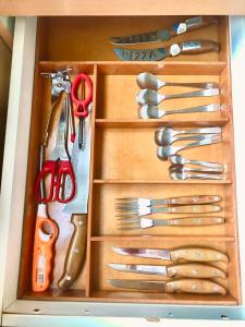 a wooden drawer filled with lots of utensils at Alquiler por dia "Como en Casa" Caseros, cerca de Palomar y Hurlingham in Caseros