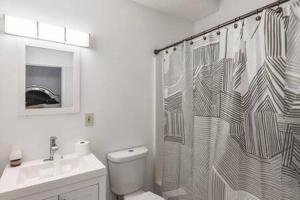 uma casa de banho com uma cortina de chuveiro, um WC e um lavatório. em Spacious Home Near Zoo Atlanta Slps 12 with Prk BBQ em Atlanta