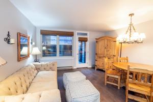 een woonkamer met een bank en een tafel bij Cozy Condo steps to Coonskin lift in Telluride