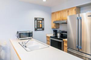 a kitchen with a stainless steel refrigerator and a sink at Cozy Condo steps to Coonskin lift in Telluride