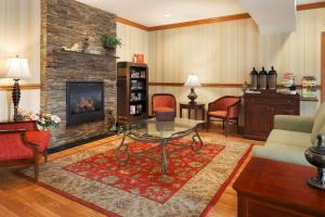 a living room with a table and a fireplace at Country Inn & Suites by Radisson, Macedonia, OH in Macedonia