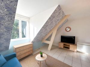a living room with a blue couch and a tv at Cosy Loft Beauvais in Beauvais
