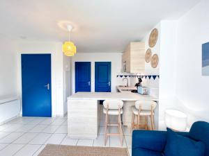 a kitchen with blue accents and a blue door at Cosy Loft Beauvais in Beauvais