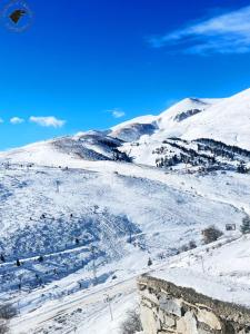 uma colina coberta de neve com montanhas ao fundo em Winterfell Apartment Popova Shapka em Popova Shapka