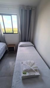 ein kleines Zimmer mit 2 Betten und einem Fenster in der Unterkunft Aconchego em Carapibus 2-Cobertura Nascente Sul in Conde