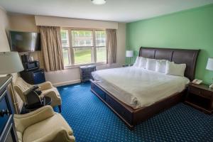 um quarto de hotel com uma cama e uma cadeira em Wonder View Inn em Bar Harbor