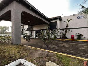 a building with two trees in front of it at Studio 6 Artesia CA in Artesia