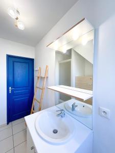 a bathroom with a sink and a blue door at Cosy Loft Beauvais in Beauvais +11 photos