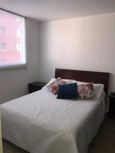 a bedroom with a bed with two pillows on it at Apartamento central in Manizales