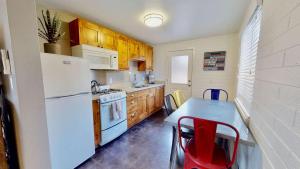 a kitchen with a table and a white refrigerator at Downtown Cozy Home Base - Purple Sage 2 in Moab