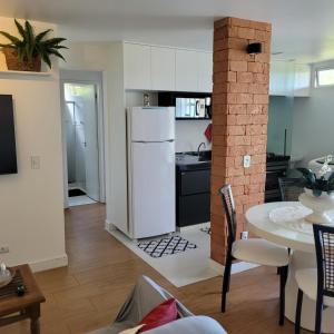 une cuisine avec un réfrigérateur blanc et une table dans l'établissement Centro de Búzios 2 quartos, à Búzios
