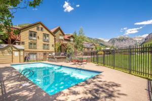 a home with a swimming pool and a fence at Ski in Ski out 2nd Floor Sweetly Updated Condo in Telluride