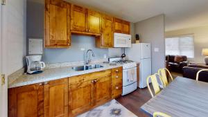 a kitchen with wooden cabinets and white appliances at Downtown Cozy Home Base - Purple Sage 3 in Moab