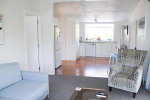 a living room with a couch and a chair and a table at Quiet, Private and Central in Tairua