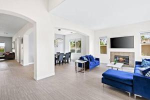 uma sala de estar com sofás azuis e uma lareira em Luxurious Getaway Near Coachella Stagecoach Pool Putting Green Parking Firepit Sleeps 11 em Indio
