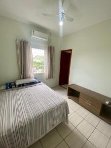 ein Schlafzimmer mit einem großen Bett und einem Fenster in der Unterkunft Pousada Sagrada Familia in Cachoeira Paulista