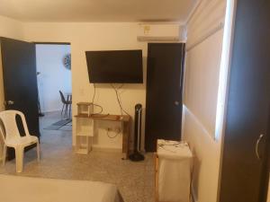 a room with a television and a table and a chair at Apartaestudio Edificio Marianna - Sector Buenavista in Barranquilla