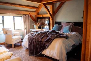 a bedroom with a large bed and a chair at housewithnonails in Matamata