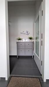 a hallway with a dresser with two plants on it at Ferienwohnung Strandmuschel in Kühlungsborn