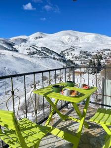 una mesa verde con un plato de comida en el balcón en Villa Winterfell Popova Shapka en Popova Shapka