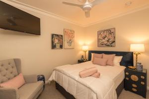 a bedroom with a bed and a chair and a television at Maleny Hotel in Maleny