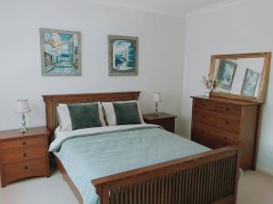 a bedroom with a bed with two dressers and a mirror at Downing Estate Homestead in Heathcote