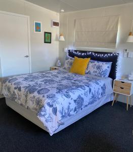 a bedroom with a bed with a blue and white bedspread at Haven On Tau in Ohakune
