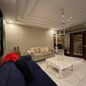 un soggiorno con divano blu e tavolo di Quinta Vela Hotel a Tegucigalpa