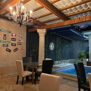 a dining room with a table and chairs and a swimming pool at Quinta Vela Hotel in Tegucigalpa