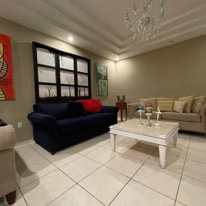 a living room with a couch and a table at Quinta Vela Hotel in Tegucigalpa