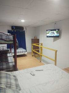 Un dormitorio con una litera y un televisor en la pared. en Departamentos Lio, en Termas de Río Hondo