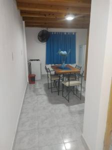 un comedor con una mesa con sillas y un jarrón de flores en Departamentos Lio, en Termas de Río Hondo 2 fotos más