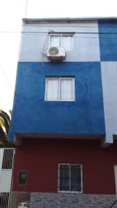 un edificio azul y blanco con ventana en Departamentos Lio, en Termas de Río Hondo