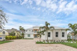 uma grande casa branca com palmeiras em frente em Infinity Pool Paradise I Luxe Waterfront Living em Edgewater
