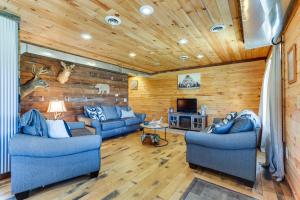 uma sala de estar com dois sofás azuis e uma televisão em Rustic Mount Perry Cabin Near Fishing Pond and Farm em Mount Perry