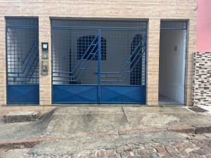una puerta de garaje azul con una escalera en ella en Casa de Guinho, en São Félix