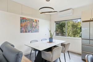 CorinellaにあるForeshore Retreatの白いテーブルと椅子のあるダイニングルーム