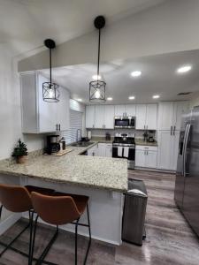 a kitchen with white cabinets and a granite counter top at Pampas House in Las Vegas