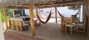 a hammock on a patio with a table and chairs at Casa Veranera Beach in Hacienda San Clemente