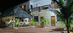 a house with a thatched roof and a palm tree at Casa Veranera Beach in Hacienda San Clemente