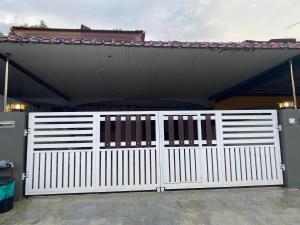 a white gate in front of a house at PJM HILL VIEW HOMESTAY in Ipoh