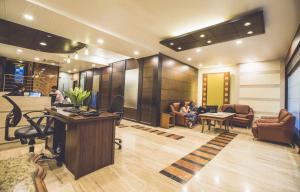 a lobby with people sitting in chairs and a desk at Hotel Airport International Mumbai in Mumbai