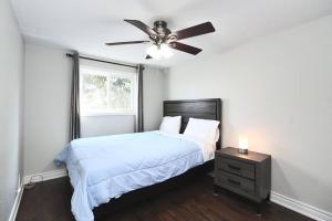 una camera con letto e ventilatore a soffitto di Barrie House near to all amenities a Barrie