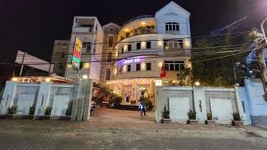 uma pessoa de pé em frente a um edifício à noite em Ngoc Son Hotel em Bien Hoa