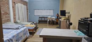 a room with two beds and a living room with a table at ARI ALOJAMIENTOS in San Juan del Paraná