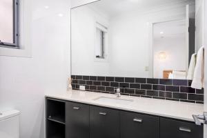 a bathroom with a sink and a mirror at Belle Escapes - Golf Villa by the Sea in Grange