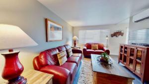 - un salon avec un canapé en cuir rouge et une table dans l'établissement Downtown Cozy Home Base - Purple Sage 5, à Moab
